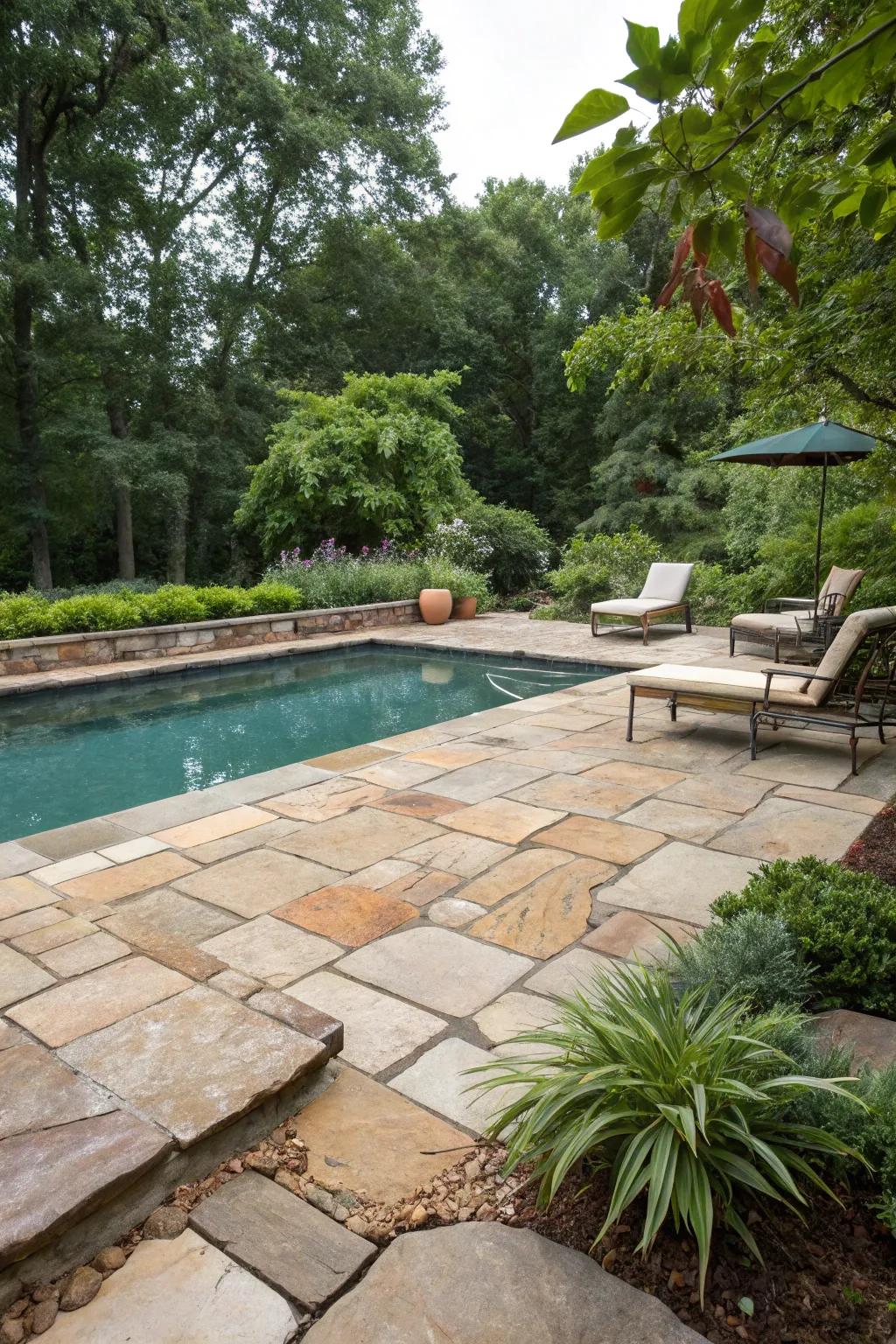 Natural stone pavers create a timeless and earthy elegance around this pool.