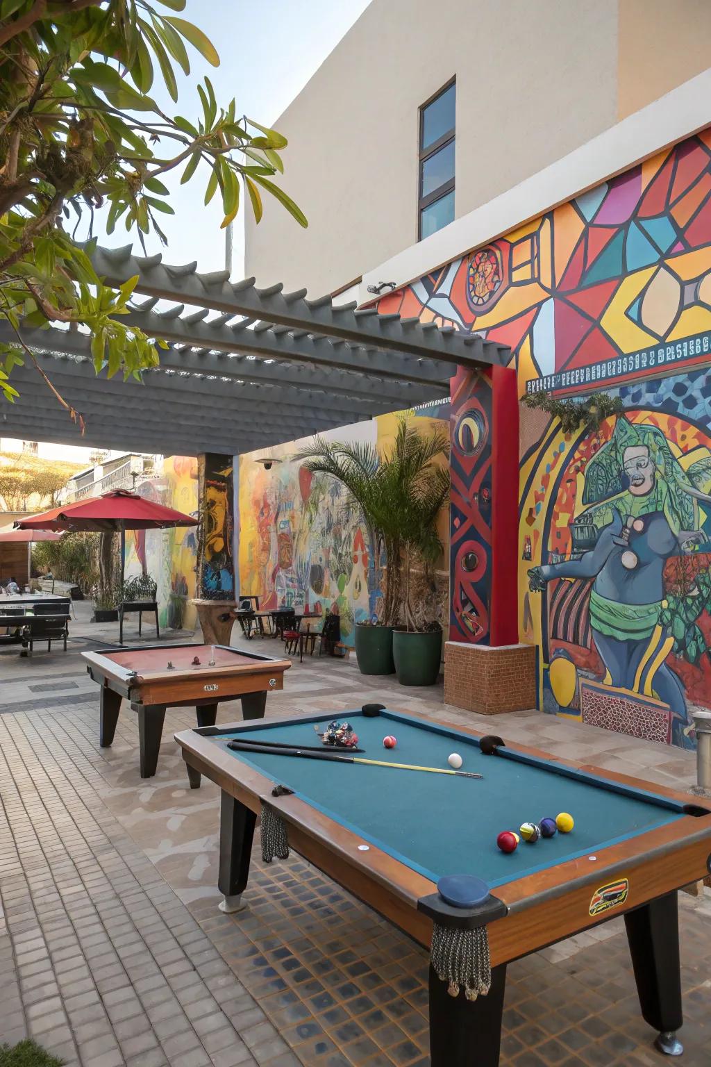 An artistic outdoor game table area adorned with murals and sculptures.