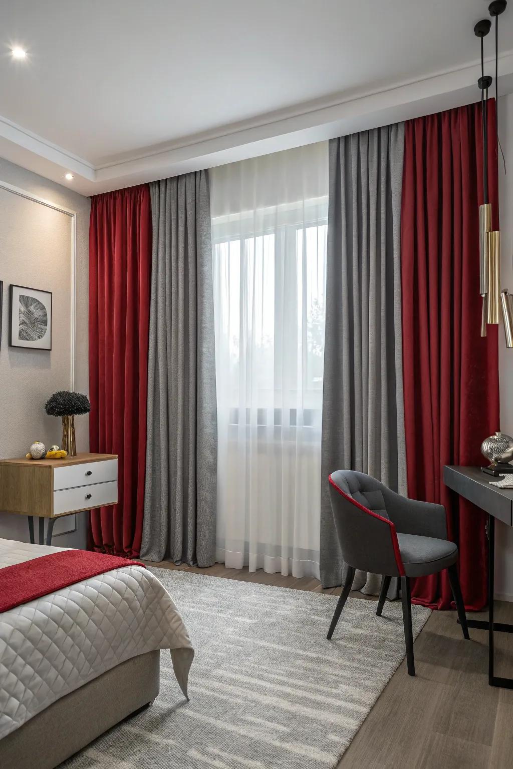Layered scarlet and charcoal drapes in a compact bedroom contribute elegance and light control.