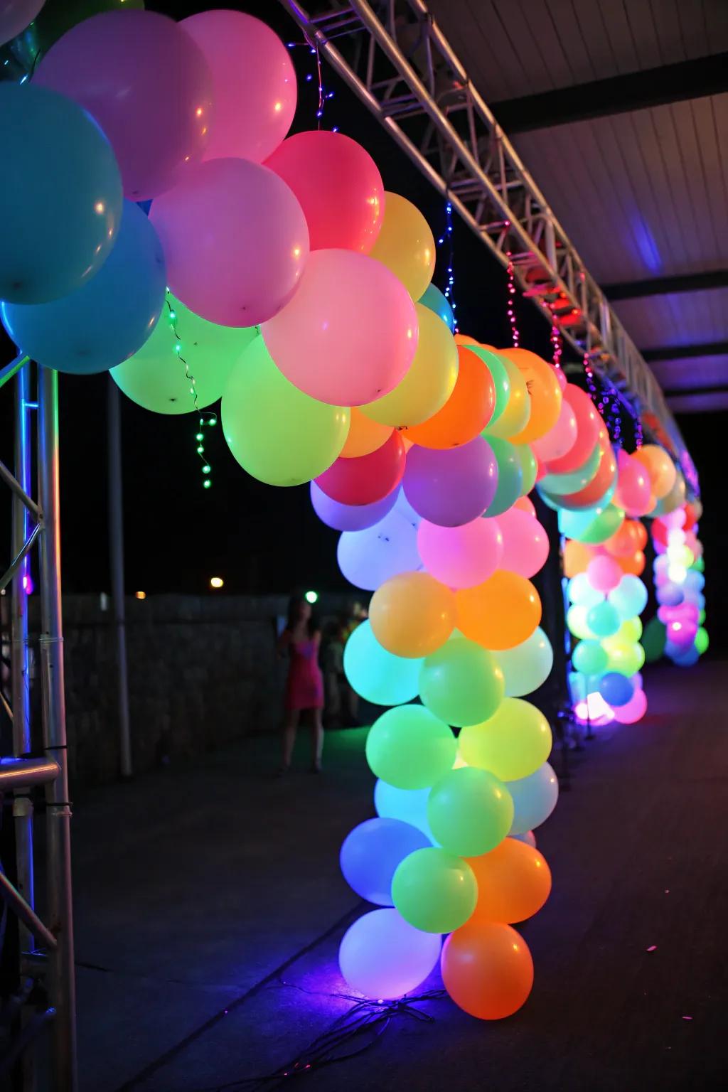 A vibrant radiant balloon garland glowing under dark light, ideal for a party setting.