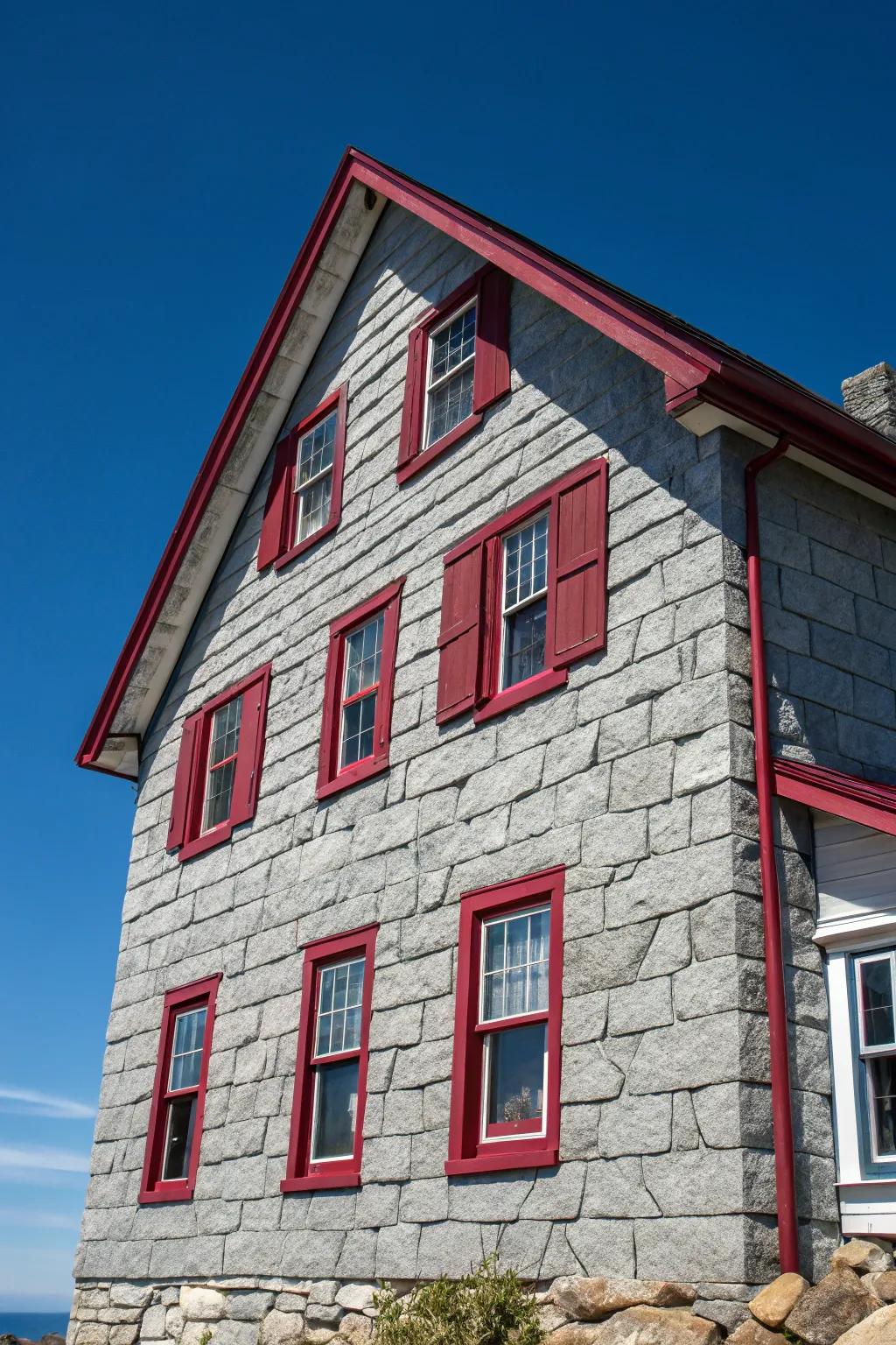 Bright red trims introduce an unexpected contrast to this gray stone exterior.