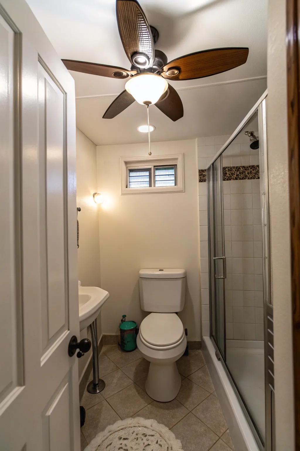 A small bathroom presenting an effective ceiling ventilator with a light.