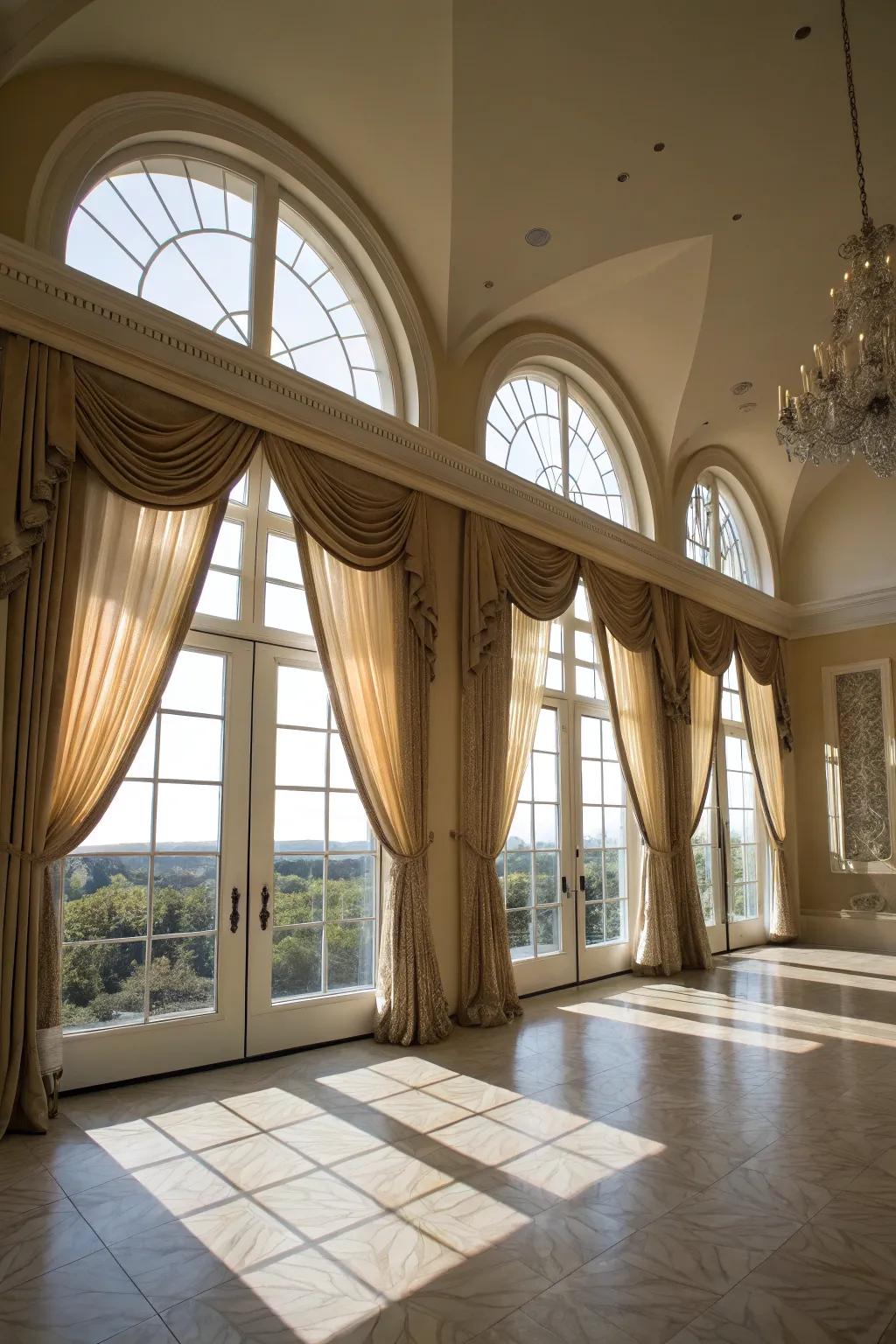 A grandiose living space features sky-mounted drapes on arched windows.